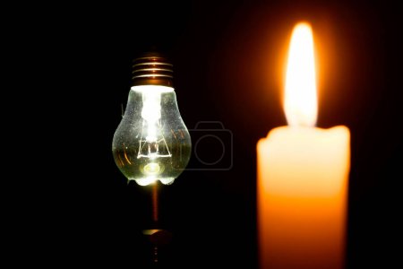 Téléchargez les photos : Bougie et lampe à incandescence la nuit sur fond noir - en image libre de droit