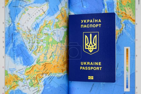 Téléchargez les photos : Passeport biométrique de l'ukraine de couleur bleue avec un trident sur le fond de la carte du pays gros plan - en image libre de droit