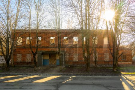 Foto de Roto edificio de ladrillo rojo de dos pisos en un día soleado brillante, Ucrania, durante la guerra en Ucrania - Imagen libre de derechos