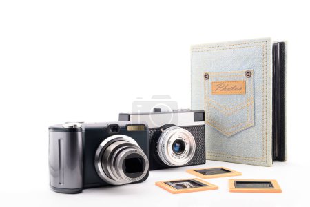 two retro 35mm film cameras and a photo album for close-up photos, on a white background