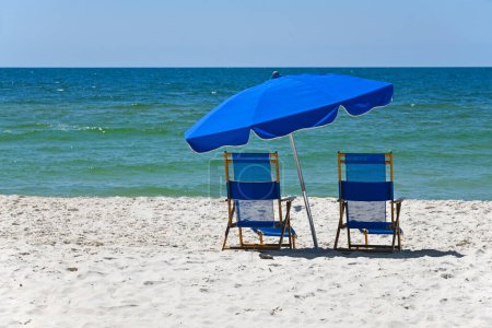 Téléchargez les photos : Chaises de plage bleues avec parapluie sur la plage de sable blanc - en image libre de droit
