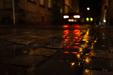 historical pavement at night with car lights background