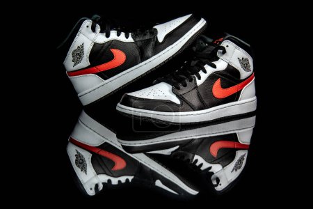 Foto de Pavía, Italia - 31 de enero de 2021: Nike Jordan 1 Mid Black Chile Red White shoes studio shot - editorial ilustrativa - Imagen libre de derechos