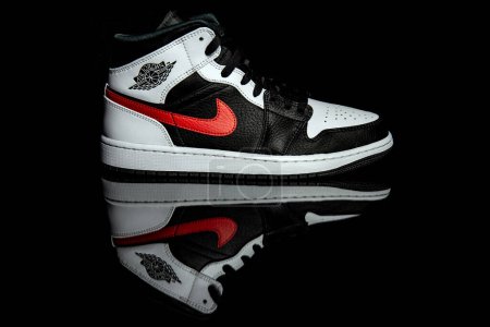 Photo for Pavia, Italy - January 31, 2021: Nike Jordan 1 Mid Black Chile Red White shoes studio shot - illustrative editorial - Royalty Free Image