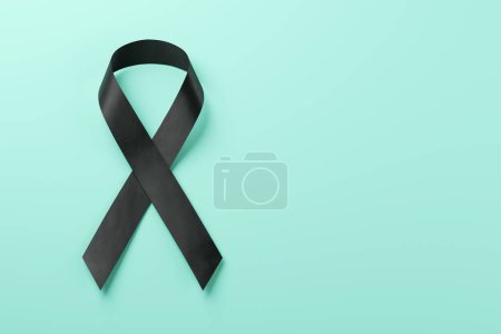 Black awareness ribbon on blue background. Mourning and melanoma symbol .