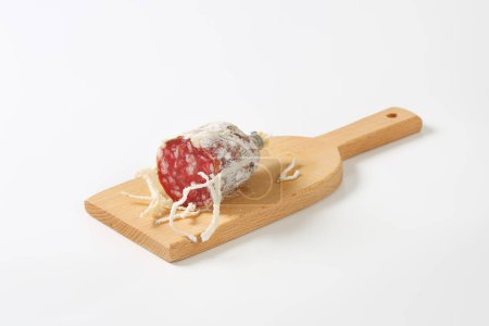 Téléchargez les photos : Saucisse française séchée sur planche à découper en bois - en image libre de droit