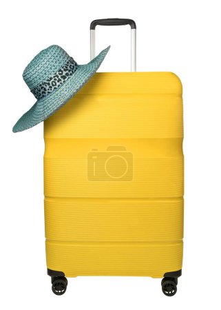 Gelber Reisekoffer mit blauem Hut auf weißem Hintergrund. Reisekoffer aus Kunststoff mit hängendem Hut. Reisekonzept