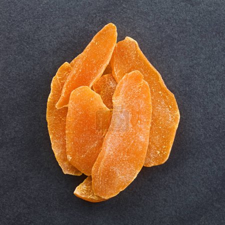 Photo for Dried candied mango fruit slices photographed overhead on slate - Royalty Free Image