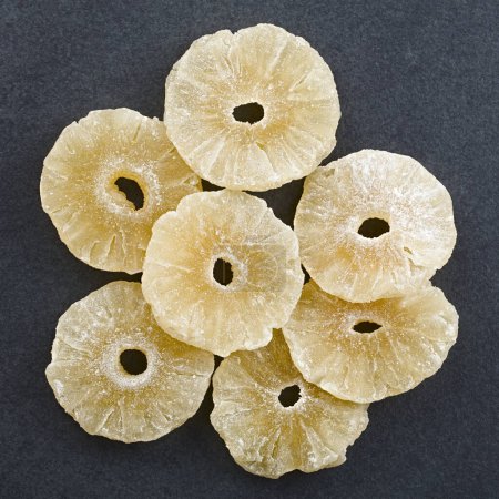 Photo for Dried candied pineapple slices photographed overhead on slate - Royalty Free Image