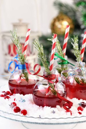Téléchargez les photos : Gin avec tonique et jus de canneberge. Le cocktail est plein de saveurs festives de Noël. Servi dans des bols transparents avec une branche de romarin. - en image libre de droit