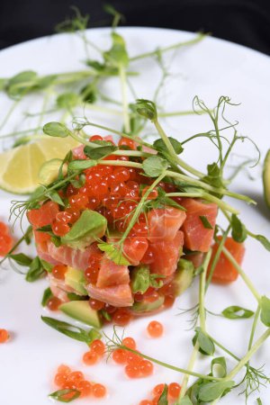 Photo for Avocado tartare with salmon, red caviar and pea sprouts. - Royalty Free Image