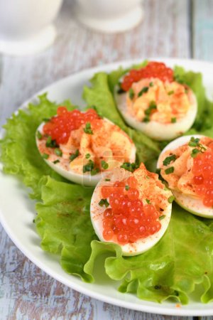 Foto de Los huevos rellenos con caviar de salmón son un aperitivo popular para cualquier ocasión. Elegantemente decoradas y sazonadas por expertos, siempre serán un aperitivo hermoso en una fiesta. - Imagen libre de derechos