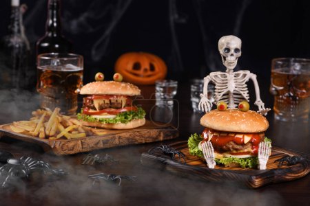Foto de Una hamburguesa monstruo en un esqueleto sentado en la niebla definitivamente levantará los espíritus y es el aperitivo de fiesta de Halloween perfecto. - Imagen libre de derechos