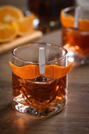 Foto de El Sharpie Mustache es un cóctel que es fácil de hacer con partes iguales de whisky de centeno, ginebra, vermut dulce y unas gotas de amargos, y adornado con una ralladura naranja en forma de bigote - Imagen libre de derechos