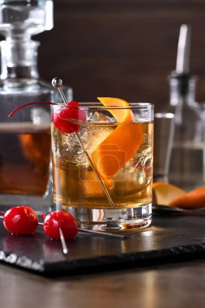 Cocktail Old Fashioned ist eine altmodische Verfeinerung von Whiskey und süßem Sirup. Serviert mit Eis, Orangenschale und Maraschino-Kirsche. 