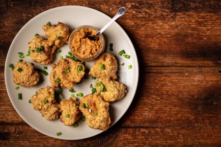 Photo for Cauliflower wings food. Pieces of cauliflower cooked in batter on a plate on a wooden background. Place for text. - Royalty Free Image