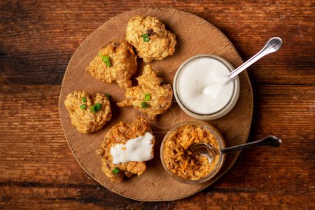 Photo for Cauliflower wings food. Pieces of flour-fried cauliflower with vegan sauces on a plate. Wooden background. Vegetarian food. - Royalty Free Image