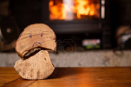 Photo for Wooden log with sad smiley. Rising price of firewood concept. Firewood against backdrop of burning fireplace. - Royalty Free Image