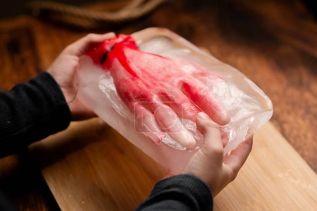 Photo for Halloween Horror: A child showcasing a frozen mannequin hand in icy grasp, evoking a Halloween-themed fright and suspenseful atmosphere, ideal for chilling visuals - Royalty Free Image