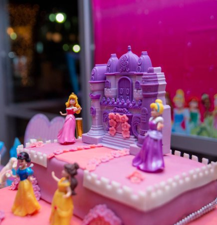 Foto de Pastel de cumpleaños rosa con vela, regalos, sombreros y decoración colorida Concepto de fiesta de cumpleaños - Imagen libre de derechos