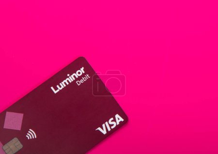 Foto de LONDRES, Reino Unido - 12 de noviembre de 2022: Tarjeta de débito sin contacto Luminor Visa sobre fondo rosa.. - Imagen libre de derechos