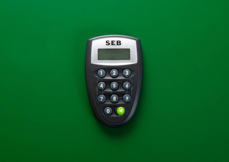 Téléchargez les photos : LONDRES, Royaume-Uni - 05 NOVEMBRE 2022 : Calculatrice de code bancaire Seb sur fond vert. Vue du dessus. - en image libre de droit