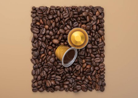 Téléchargez les photos : Capsules de café sur grains de café carrés texture sur fond beige avec café moulu.. - en image libre de droit