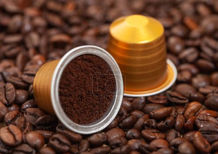 Téléchargez les photos : Capsules avec café moulu sur des haricots aromatiques frais crus. - en image libre de droit