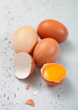 Foto de Huevos orgánicos frescos crudos con cáscara y yema en mesa de cocina ligera. - Imagen libre de derechos