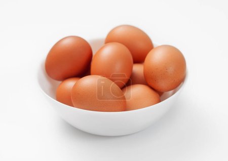 Foto de Huevos crudos orgánicos marrones en plato hondo blanco. - Imagen libre de derechos