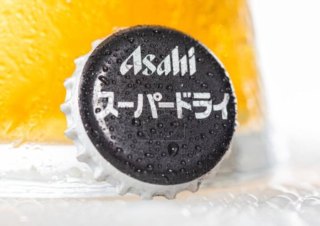 Téléchargez les photos : LONDON, UK - DECEMBER 22, 2022: Asahi super dry beer bottle cap with dew and cold glass on white. - en image libre de droit