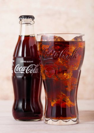 Téléchargez les photos : LONDRES, ROYAUME-UNI - 03 AOÛT 2018 : Bouteille en verre et verre original de boisson gazeuse Zero Sugar Coca Cola sur bois. Boisson la plus populaire au monde - en image libre de droit