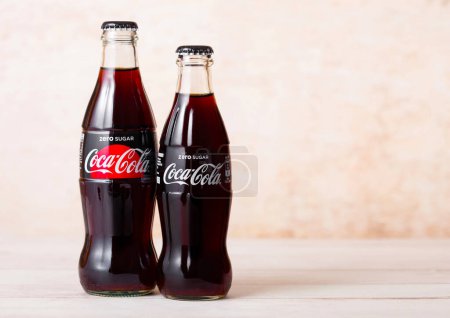 Téléchargez les photos : LONDON, UK - AUGUST 03, 2018: Glass bottles of Zero Sugar Coca Cola soft drink on wood. Most popular drink in the world - en image libre de droit