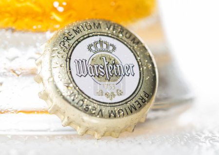 Téléchargez les photos : LONDON, UK - DECEMBER 12, 2022: Warsteiner lager beer bottle cap with dew and cold glass on white. - en image libre de droit