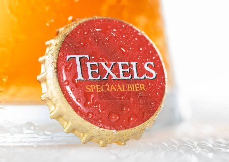 Foto de LONDON, UK - DECEMBER 29, 2022: Texels craft beer bottle cap with cold glass on white. Product of Netherlands. - Imagen libre de derechos