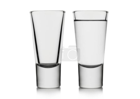 Photo for Classic empty and full shot glasses with tequila or vodka on white background. - Royalty Free Image