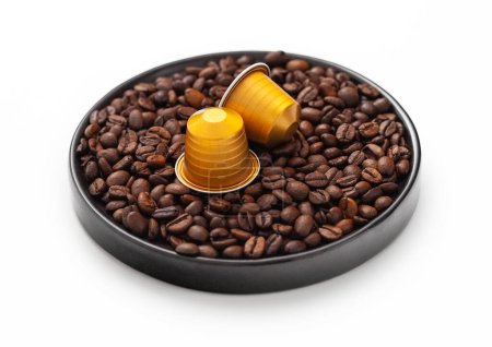 Téléchargez les photos : Coffee capsules suitable for machine on round plate on white with raw coffee beans. - en image libre de droit