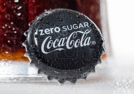 Téléchargez les photos : LONDRES, Royaume-Uni - 29 DÉCEMBRE 2022 : Coca Cola Zere Bouchon de bouteille de sucre avec verre froid sur fond de rosée. - en image libre de droit