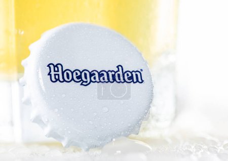 Photo for LONDON, UK - DECEMBER 15, 2022: Hoegaarden wheat beer bottle cap with dew on white with glass. - Royalty Free Image