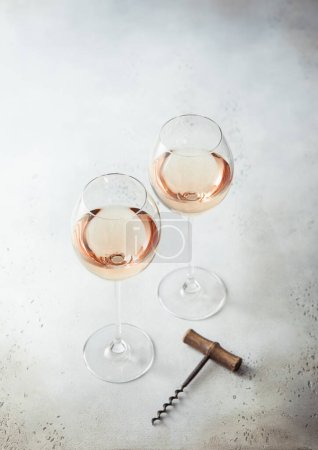 Téléchargez les photos : Lunettes de vin rose et tire-bouchon vintage sur fond clair. - en image libre de droit