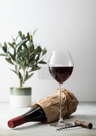 Foto de Botella de vino en bolsa de papel con abrelatas y copa de vino. - Imagen libre de derechos