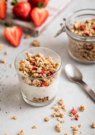 Photo for Natural yogurt with strawberry granola and fresh berries with spoon. - Royalty Free Image