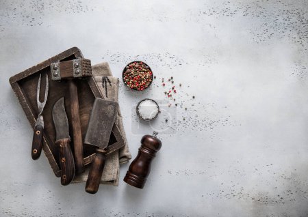 Photo for Box of various vintage meat preparation utensils with pepper grinder and salt.Top view. - Royalty Free Image