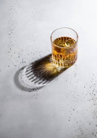 Foto de Whisky en cristal con cubitos de hielo y sombra negra.Luz dura - Imagen libre de derechos