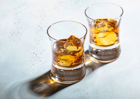 Téléchargez les photos : Lunettes de whisky avec glaçons sur fond clair. Macro - en image libre de droit