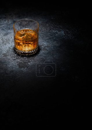 Téléchargez les photos : Verre à whisky avec glaçons au milieu du fond noir. Vue du dessus. - en image libre de droit