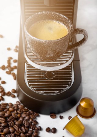 Photo for Black coffee cup and home espresso machine with coffee capsules on white marble kitchen. - Royalty Free Image