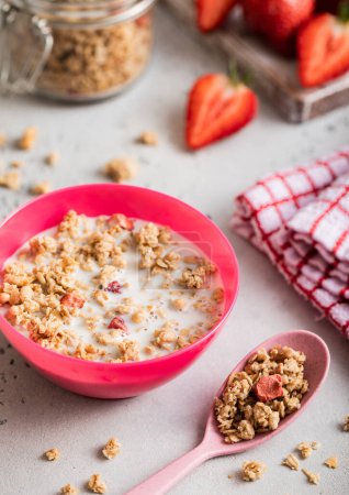 Photo for Homemade organic strawberry granola with milk in morning kitchen with spoon. - Royalty Free Image
