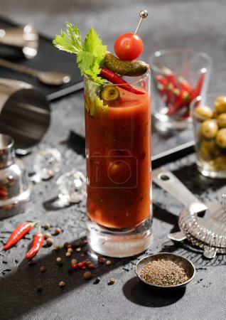 Téléchargez les photos : Cocktail marie sanglant à la vodka et au jus de tomate avec cuillère, passoire et olives au bar au poivre noir moulu.. - en image libre de droit
