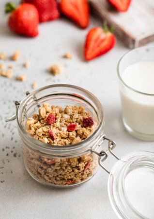 Photo for Jar of fresh organic natural strawberry granola in light kitchen background. - Royalty Free Image